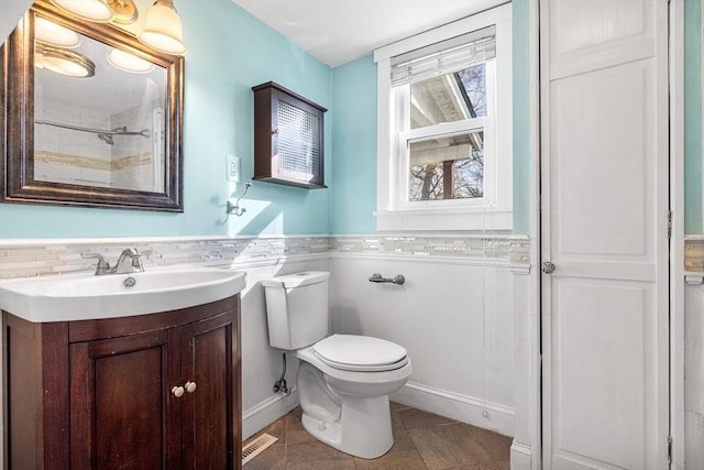 bathroom with toilet, tile patterned flooring, and vanity