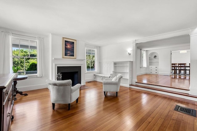 living room with built in shelves and light wood-type flooring