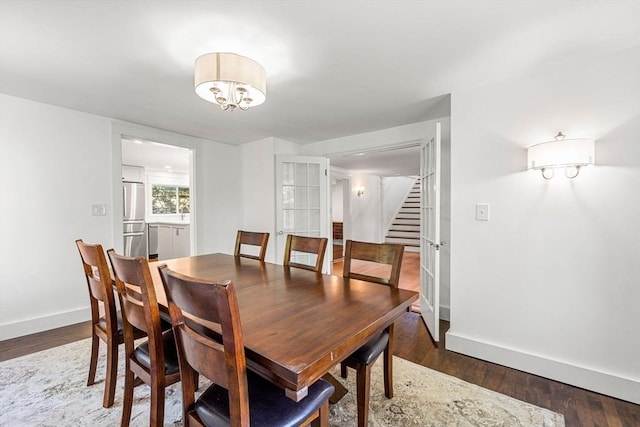 dining space featuring dark hardwood / wood-style floors and a notable chandelier