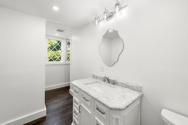 bathroom featuring vanity, toilet, and wood-type flooring