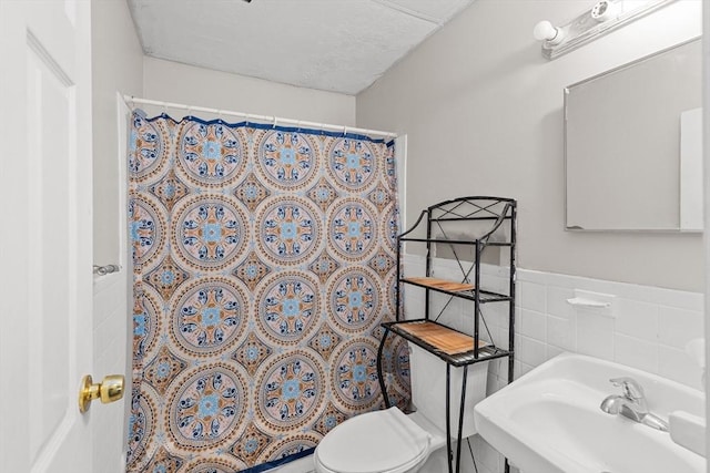 bathroom featuring tile walls, sink, and toilet