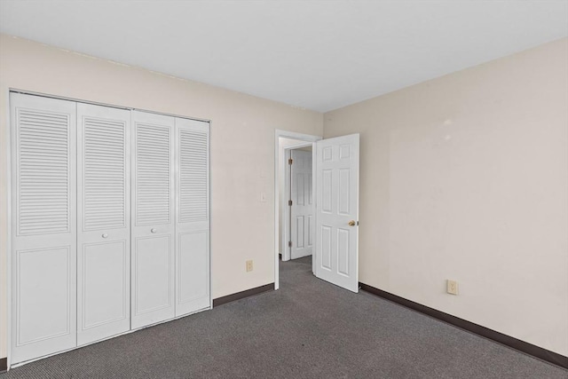 unfurnished bedroom featuring a closet and dark colored carpet