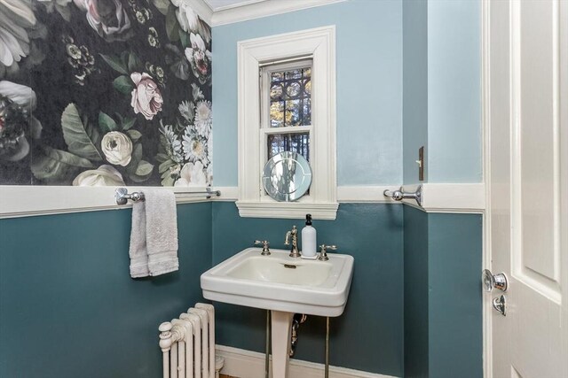 bathroom featuring a sink, radiator, and ornamental molding
