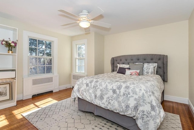 bedroom featuring radiator heating unit, baseboards, ceiling fan, and wood finished floors