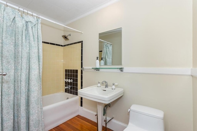 bathroom featuring toilet, ornamental molding, wood finished floors, and shower / tub combo with curtain