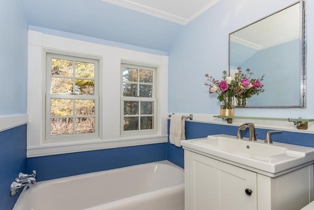 bathroom with crown molding, vanity, and a bathtub