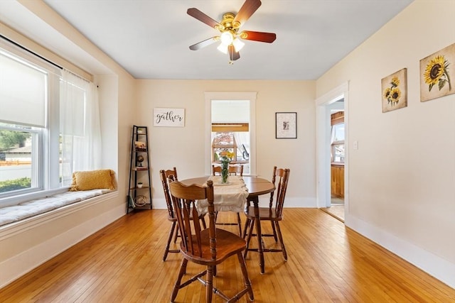 dining space with healthy amount of natural light, light wood-type flooring, and a ceiling fan