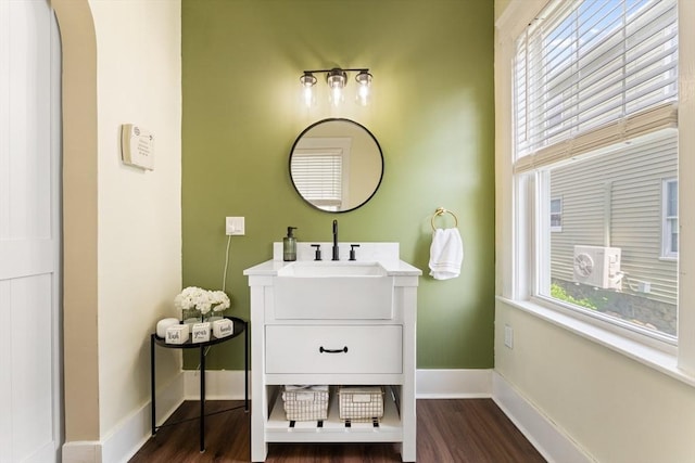 bathroom with wood finished floors, baseboards, and vanity