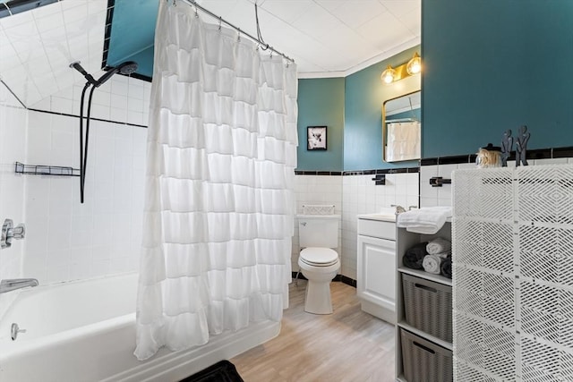 bathroom with shower / bath combo, tile walls, wood finished floors, toilet, and vanity