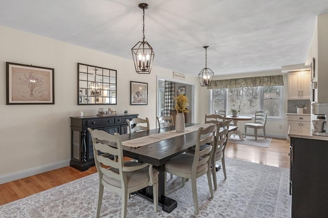 dining space with light wood-style floors and baseboards