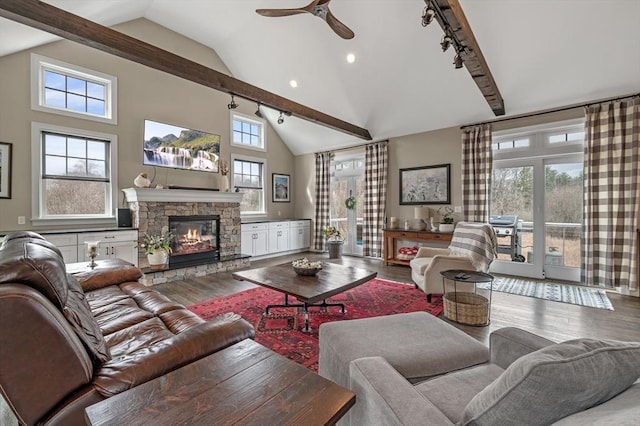 living room with track lighting, a fireplace, a ceiling fan, and wood finished floors
