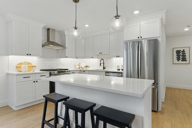 43-45 Wellington St Unit 2, Waltham, MA 02451 - kitchen featuring wall chimney exhaust hood, appliances with stainless steel finishes, decorative backsplash, white cabinets, and light countertops