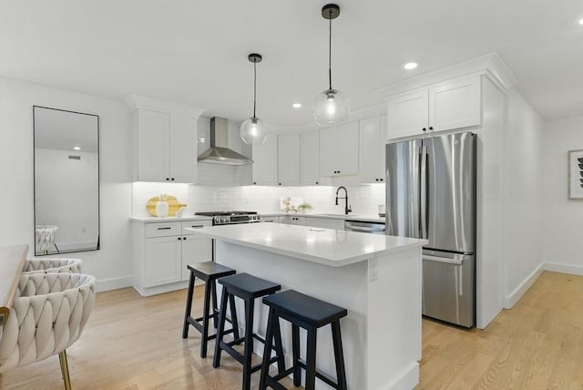 43-45 Wellington St Unit 2, Waltham, MA 02451 - kitchen featuring wall chimney exhaust hood, appliances with stainless steel finishes, light wood-style floors, white cabinets, and recessed lighting
