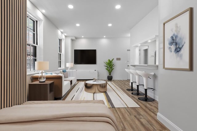 living room with a wealth of natural light, recessed lighting, baseboards, and wood finished floors