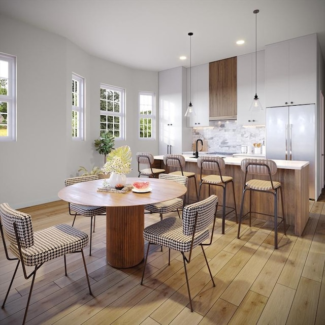 dining room with light wood-type flooring and recessed lighting