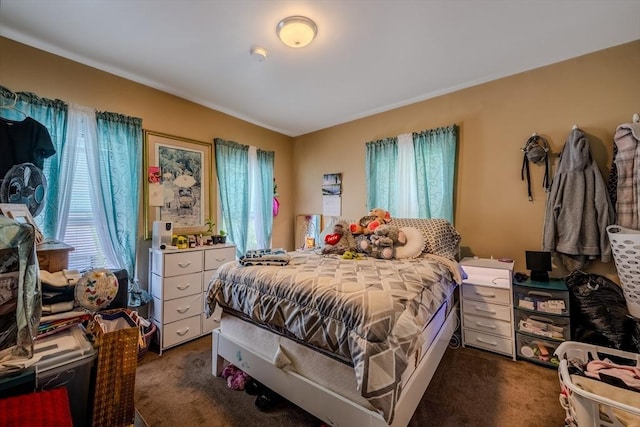 bedroom with dark colored carpet and multiple windows