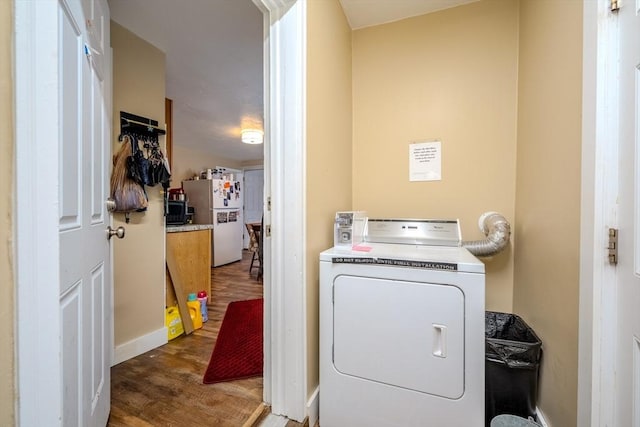 washroom with washer / dryer, wood finished floors, and baseboards