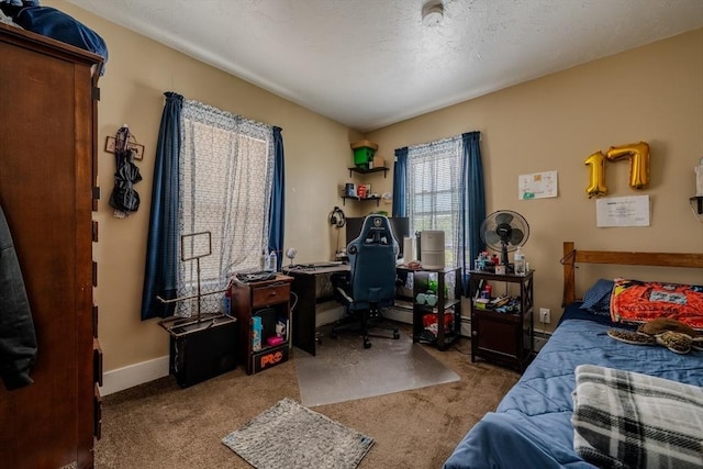 carpeted bedroom featuring a desk and baseboards