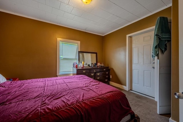 carpeted bedroom featuring ornamental molding and baseboards