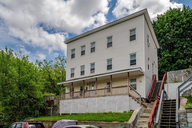 back of property featuring stairs and a porch