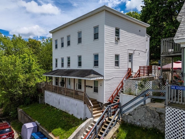 back of house featuring stairs and a porch