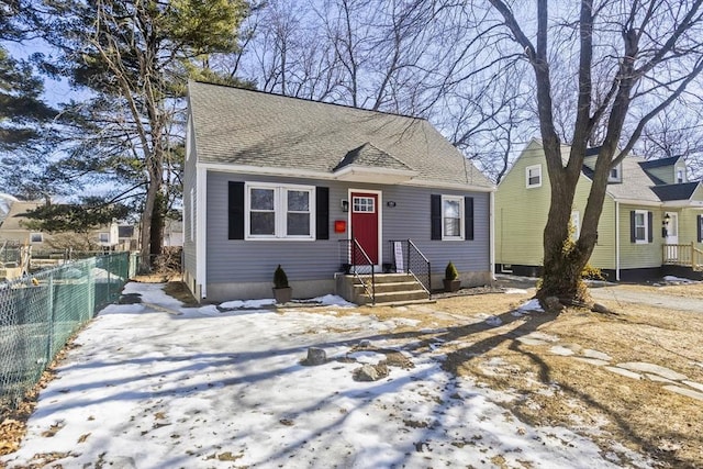 bungalow-style house featuring a shingled roof and fence