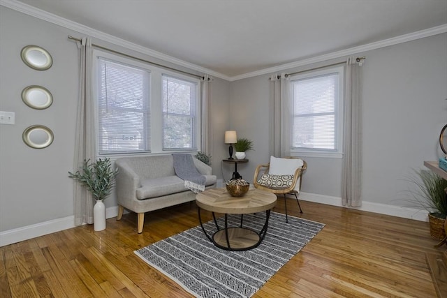 sitting room with baseboards, wood finished floors, and crown molding