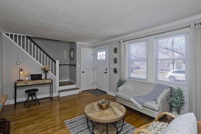 living room featuring baseboards, crown molding, stairway, and wood finished floors