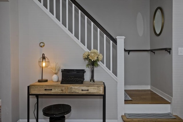 stairs featuring wood finished floors and baseboards