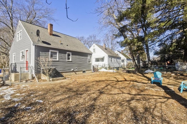 rear view of property featuring roof with shingles, fence, and a chimney