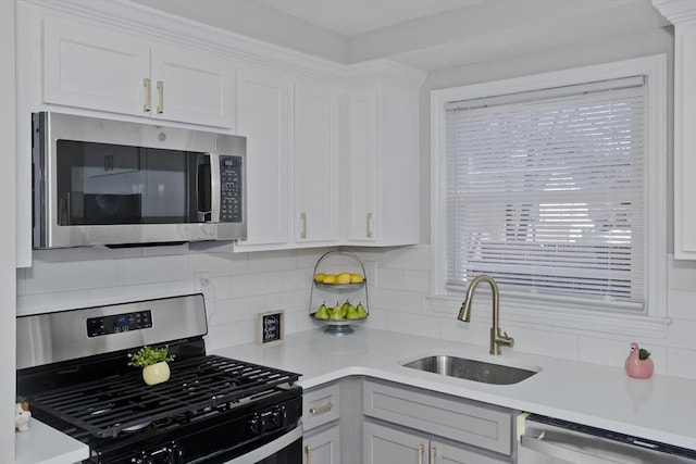 kitchen featuring tasteful backsplash, stainless steel appliances, a sink, and light countertops