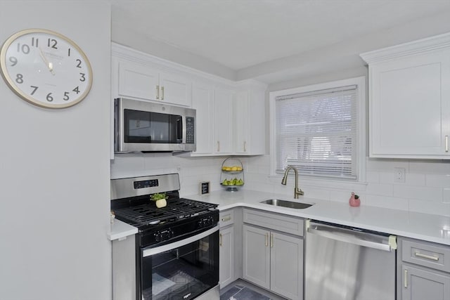 kitchen featuring stainless steel appliances, tasteful backsplash, a sink, and light countertops