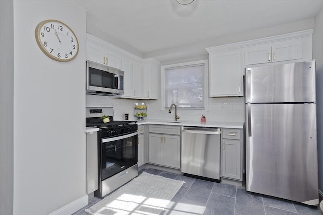 kitchen featuring stainless steel appliances, gray cabinets, light countertops, and tasteful backsplash