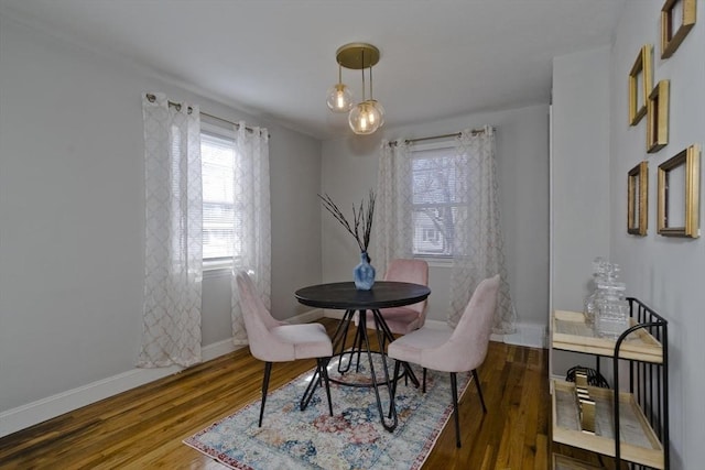 dining area with baseboards and wood finished floors