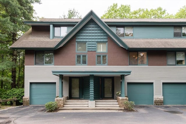 1175 Chestnut St Unit 33, Newton, MA 02464 - view of front of house with a garage, driveway, covered porch, and a shingled roof