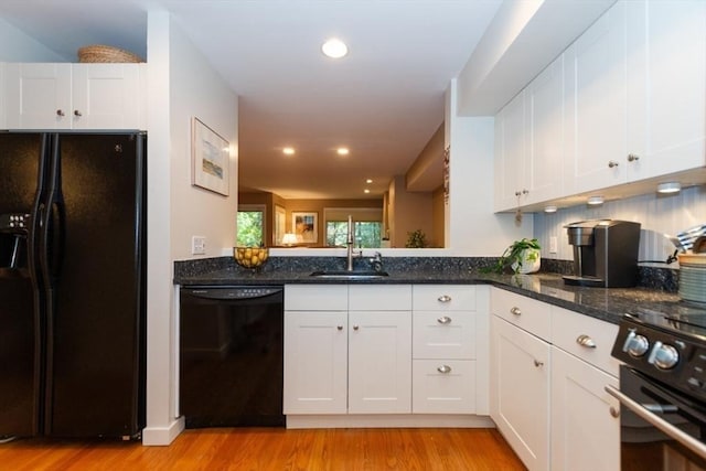 1175 Chestnut St Unit 33, Newton, MA 02464 - kitchen featuring black appliances, light wood-style floors, a sink, white cabinetry, and dark stone counters