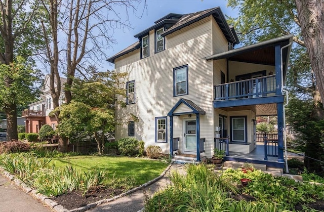 409-411 Atlantic Ave Unit 409, Marblehead, MA 01945 - view of front facade with a balcony, a porch, and a front yard