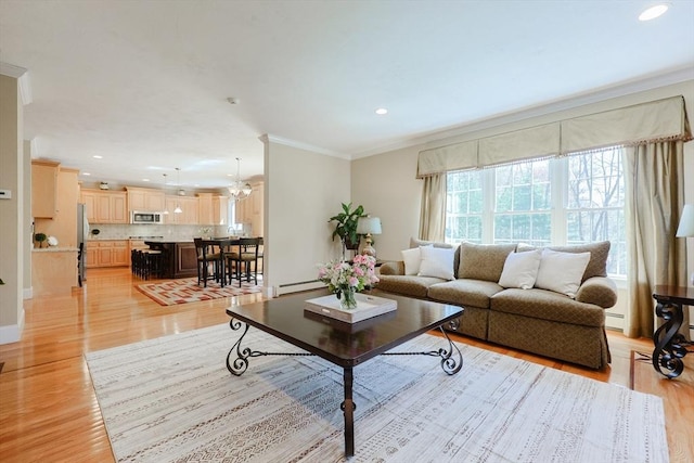 living room featuring light wood-style floors, ornamental molding, baseboard heating, and recessed lighting