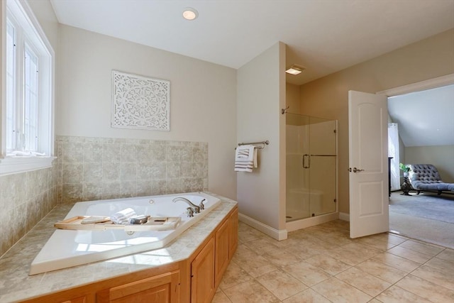 full bathroom with tile patterned floors, a tub with jets, a healthy amount of sunlight, and a stall shower