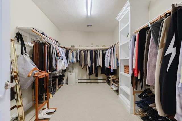 walk in closet with carpet flooring, a baseboard heating unit, and visible vents