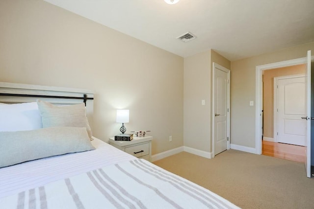 carpeted bedroom featuring visible vents and baseboards