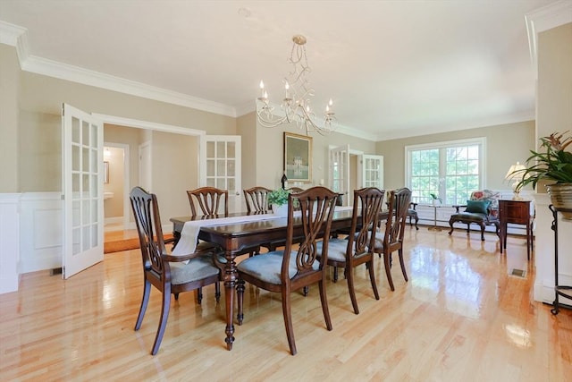 dining area with light wood-style floors, a notable chandelier, and french doors