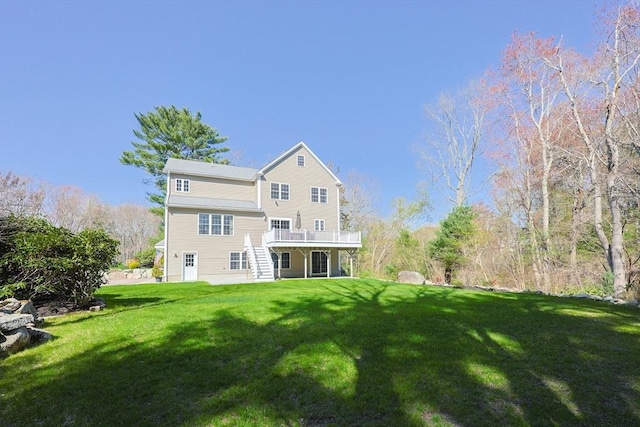 back of property featuring a lawn and a wooden deck