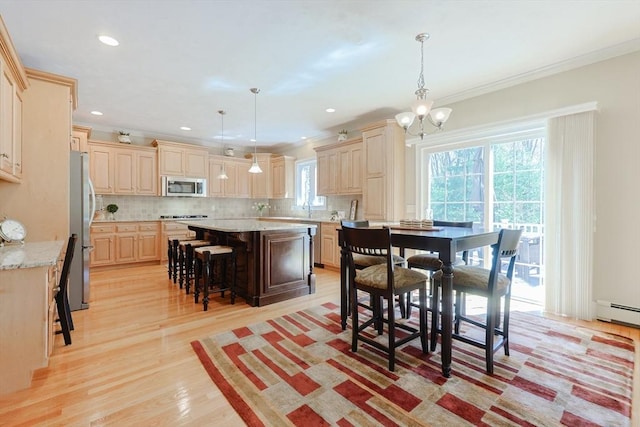 dining area with a chandelier, ornamental molding, a wealth of natural light, and light wood-type flooring