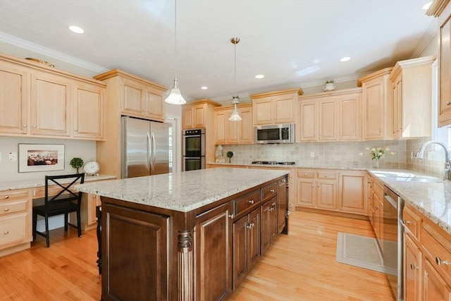 kitchen with a sink, light brown cabinets, stainless steel appliances, and light wood-type flooring