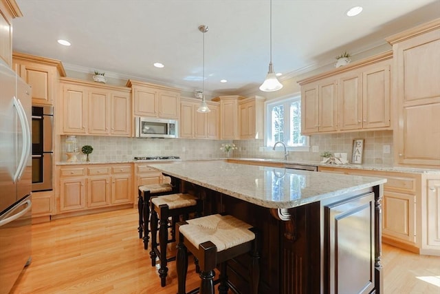 kitchen featuring appliances with stainless steel finishes, light wood finished floors, and light brown cabinets