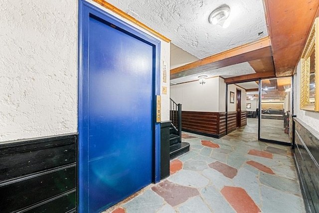 50 Follen St Unit 306, Cambridge, MA 02138 - corridor featuring stone floors, stairway, a textured ceiling, and wainscoting