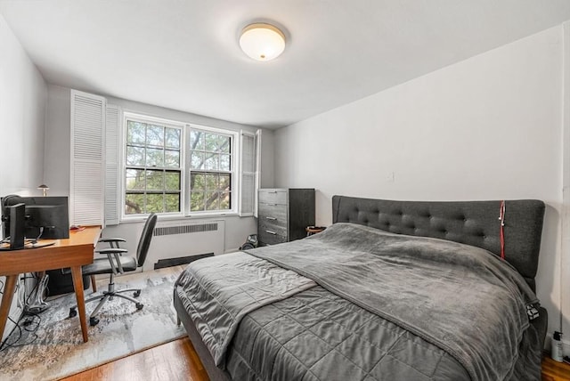50 Follen St Unit 306, Cambridge, MA 02138 - bedroom with radiator heating unit, wood finished floors, and a desk