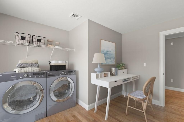 clothes washing area featuring independent washer and dryer and light hardwood / wood-style floors