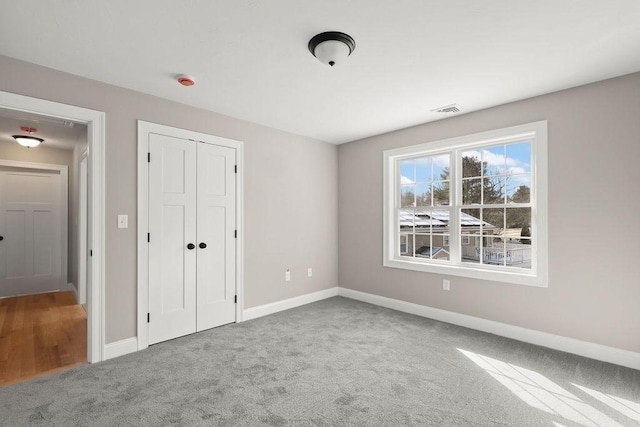 unfurnished bedroom with carpet flooring and a closet